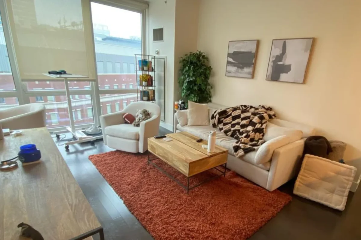 Airbnb living room with blankets thrown on sofa and items scattered after guest checkout in NYC
