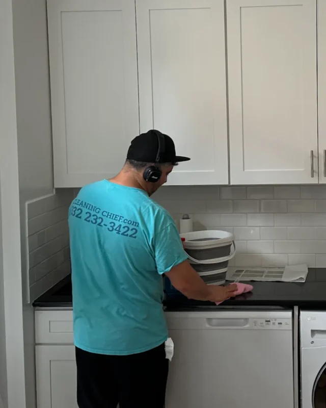 Cleaning Chief cleaner wiping black kitchen countertop in NYC Airbnb apartment