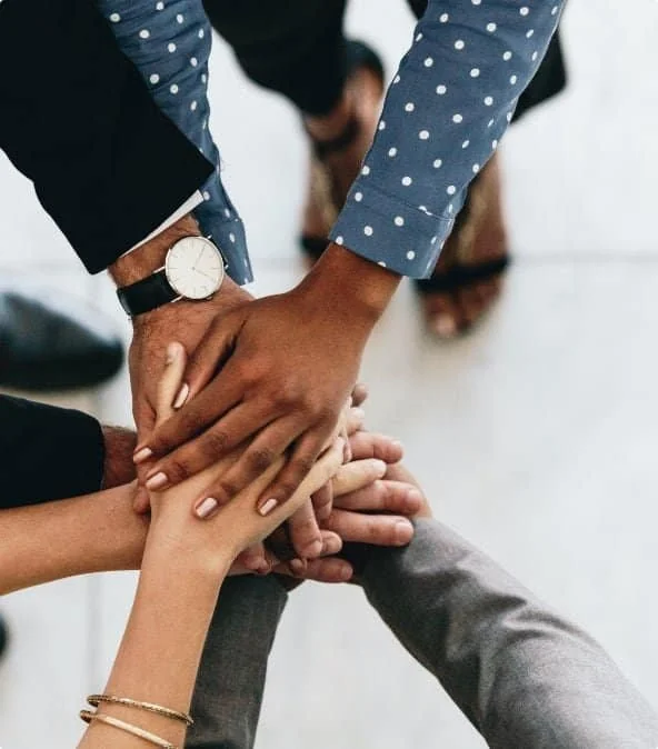 Diverse Cleaning Chief team members placing their hands together in a show of teamwork and unity