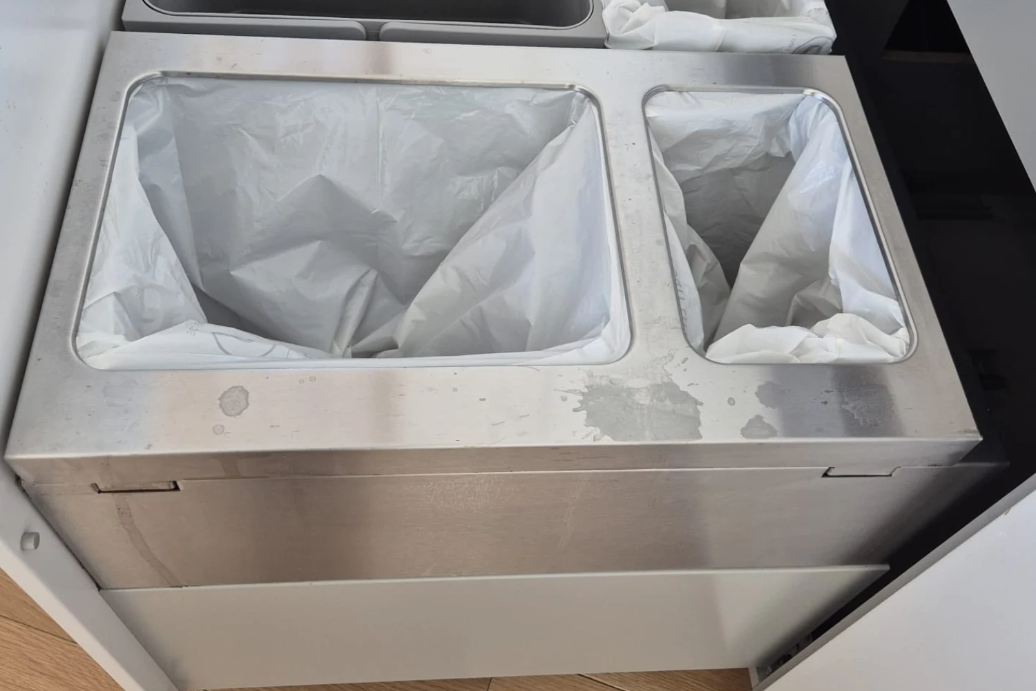 Smudged stainless steel kitchen trash bins before Cleaning Chief VIP deep clean