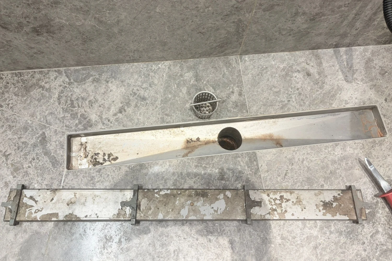 Grimy rust-stained shower drain before Cleaning Chief VIP bathroom deep clean