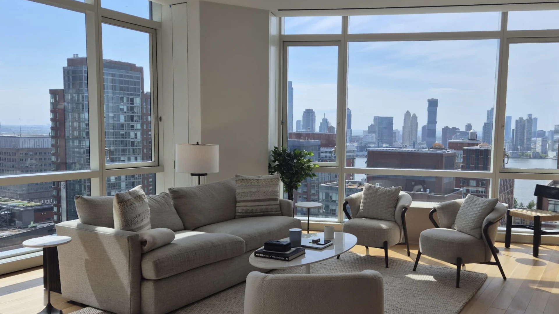 Luxury high-rise Manhattan apartment living room with panoramic NYC skyline and Hudson River views