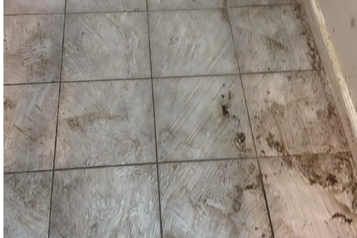 Tile floor covered in dried dirt and heavy grime before deep cleaning service in NYC