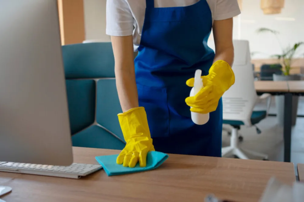 Cleaning Chief professional performing desk and equipment disinfection in NYC