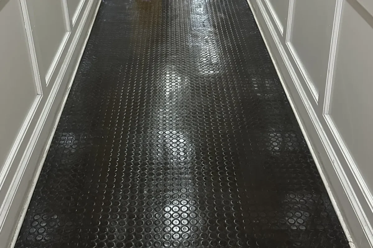 Same NYC hallway rubber coin-dot floor now gleaming and reflective after professional floor buffing