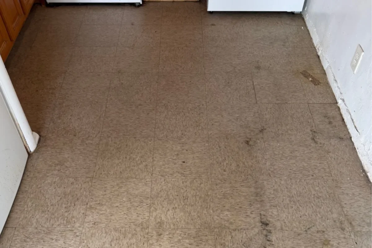 Kitchen vinyl tile floor heavily stained and soiled before Cleaning Chief floor buffing service in NYC