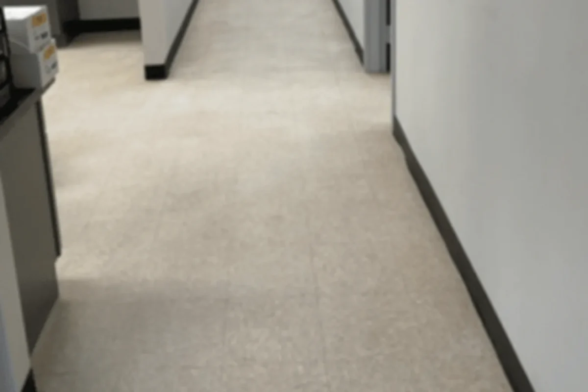 Office corridor with dull worn vinyl composition tile floor before janitorial service in NYC