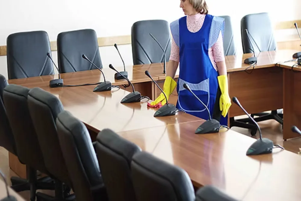 Cleaning Chief professional performing meeting room reset in NYC