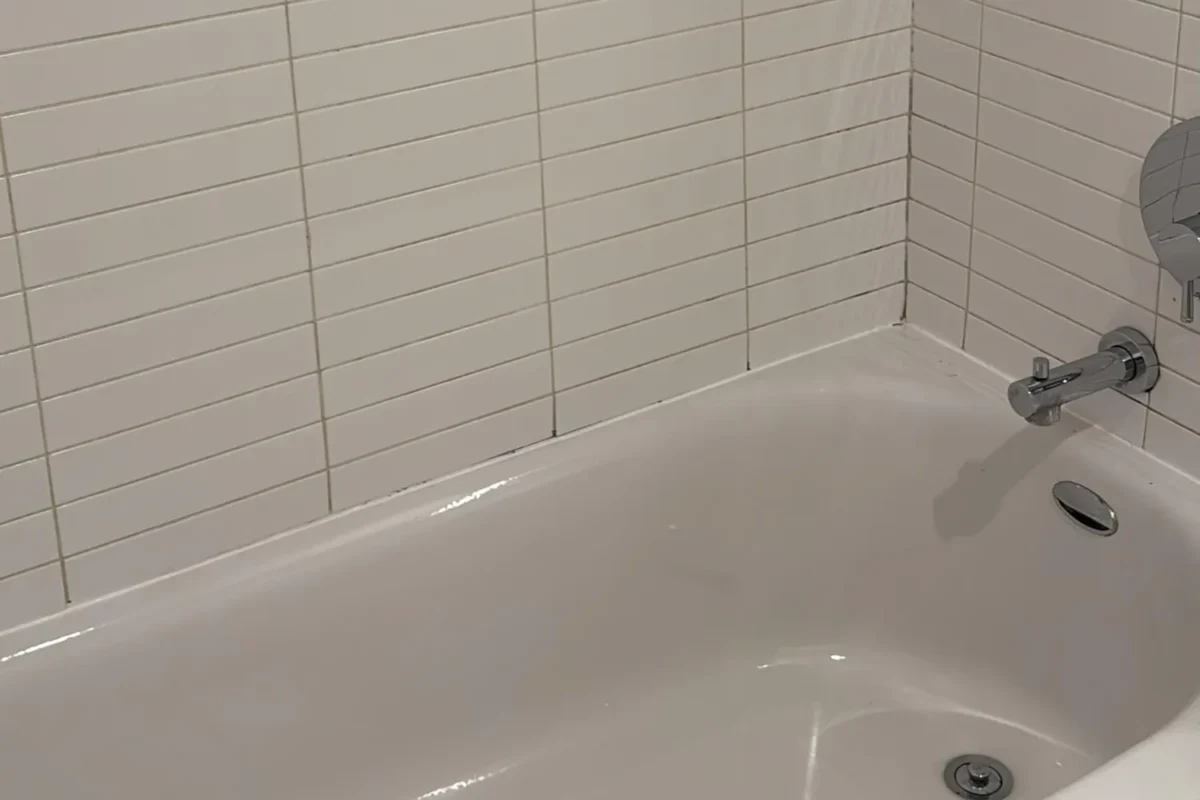 Sparkling clean white bathtub with no mold and polished chrome fixtures after move-out cleaning in NYC