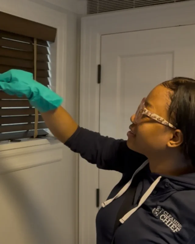 Cleaning Chief cleaner in gloves wiping window blinds during move-in cleaning in NYC