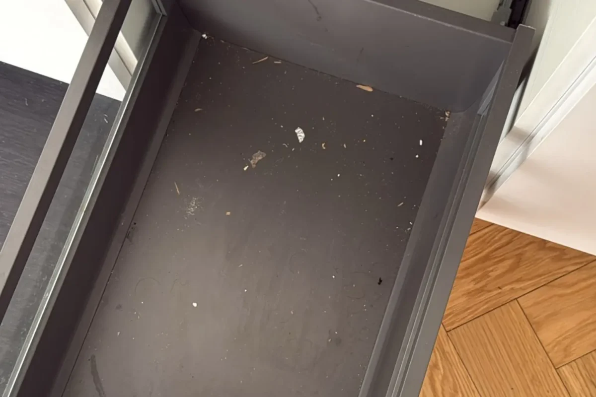 Kitchen drawer filled with construction dust and debris before post-construction cleaning in NYC