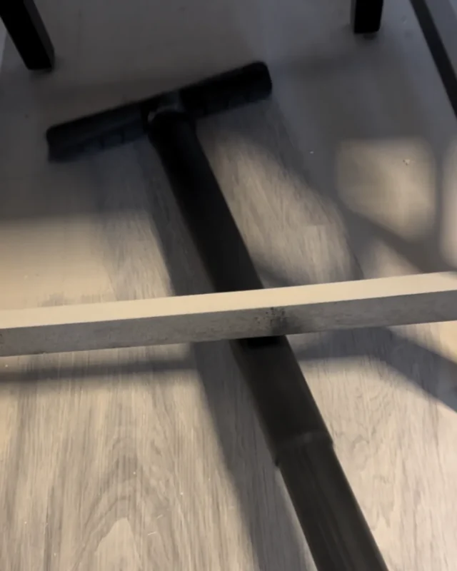 Close-up of floor squeegee tool being used on vinyl plank floor during post-construction cleaning in NYC