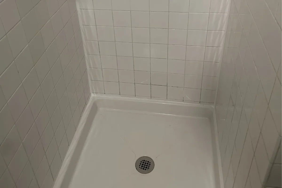 Shower stall with no mold, bright white tiles and clean grout lines after tile cleaning service in NYC
