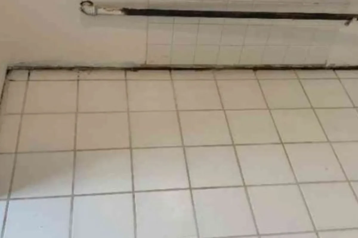 White commercial wall tiles with cleaned surface near ceiling rod after commercial power washing service in NYC