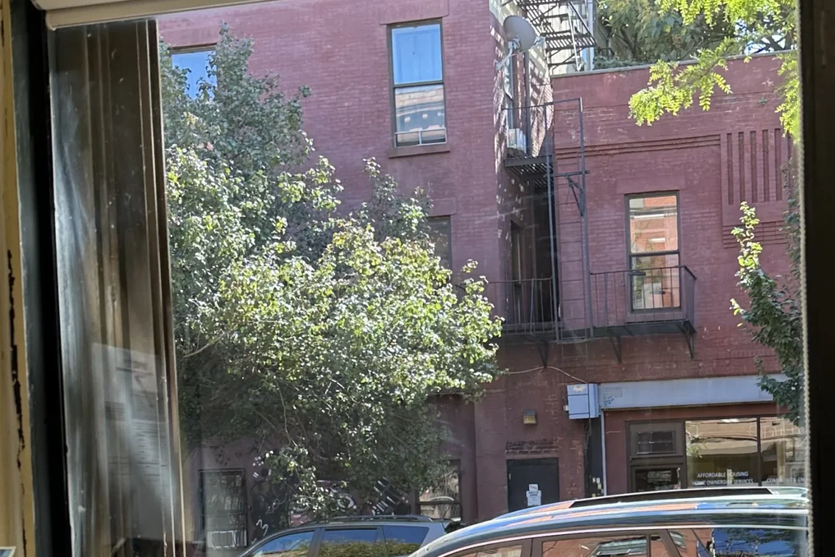 Same NYC apartment window now crystal clear with unobstructed view of street and buildings after cleaning